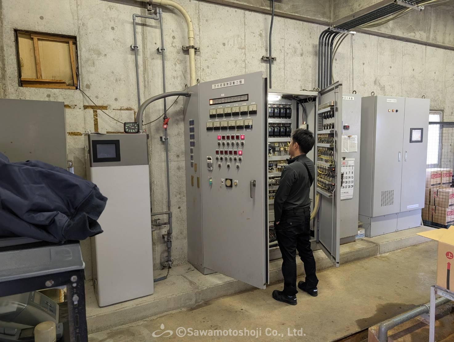既存の制御盤の仕様を確認する澤本商事の担当者